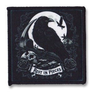 May include: Black and white embroidered patch featuring a raven perched on a tombstone beneath a full moon. The patch includes a banner with the text "Rest in Pieces".