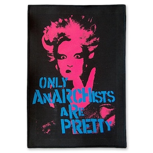 Op de afbeelding: Zwart rechthoekig textiel met een roze en blauwe afbeelding. De afbeelding toont een gestileerd gezicht met roze haar en de tekst "ONLY ANARCHISTS ARE PRETTY" in blauw.
