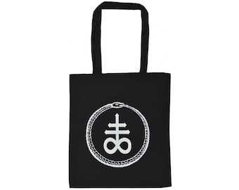 May include: Black tote bag with white graphic. The graphic is a symbol within a circle, with a snake eating its tail. The bag has two black handles. The symbol is a cross with an 8 below it.