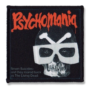 May include: A black fabric patch with the text "PSYCHOMANIA" in red lettering. The patch features a black and white illustration of a skull wearing white goggles and a pair of crossed bones. The text "Seven Suicides - and they roared back at The Living Dead" is printed below the skull.