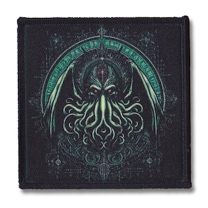 May include: A black fabric patch featuring a green and blue illustration of Cthulhu, a fictional creature from the works of H.P. Lovecraft. The illustration is surrounded by a circle of text and symbols.