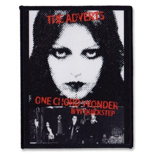 May include: Black and white image of a woman's face with the text "THE ADVERTS" above and "ONE CHORD WONDER B/W QUICKSTEP" below. The image is on a black fabric patch.
