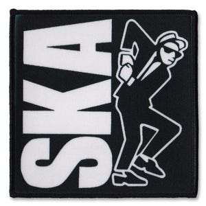 May include: Square black and white patch with the word "SKA" in large white letters. A silhouette of a man in a suit and hat, in a dancing pose, is on the right. The patch has a black border.