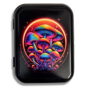 Peut inclure: Une boîte en métal noir avec un motif de champignons psychédéliques colorés. Les champignons brillent dans des tons de rose, violet, bleu et vert sur un fond noir avec une auréole rouge et orange.