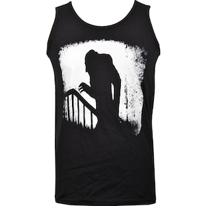 May include: Black vest top with a white graphic of a silhouetted figure on a staircase. The figure is reaching out, with a distressed white border around the image. The vest top is made of a soft, dark fabric.