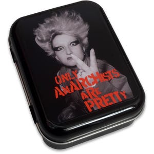 May include: Black rectangular tin featuring a grayscale image of a person giving a peace sign. The text "ONLY ANARCHISTS ARE PRETTY" is in red. The tin has a shiny, reflective surface.