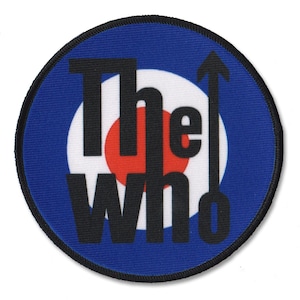 May include: A circular embroidered patch featuring a blue, white, and red target design. The black text reads The Who, with the letter O stylized as an upward-pointing arrow. The patch has a thick black stitched border around the entire circumference.