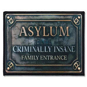 Könnte beinhalten: Ein schwarzes und goldenes Schild mit der Aufschrift "Asylum for the Criminally Insane Family Entrance".