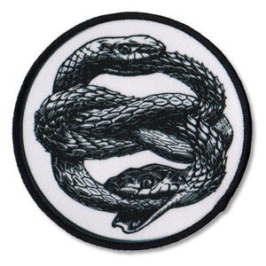 Könnte beinhalten: Ein weißer runder Patch mit einem schwarz-weißen Bild von zwei ineinander verschlungenen Schlangen in einem Kreis.