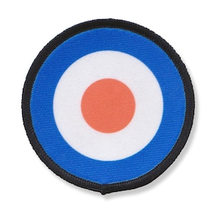 Peut inclure: Un patch rond bordé de noir avec un motif de cible bleu, blanc et orange.