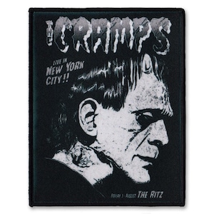 May include: Black and white patch featuring a graphic of a man's face and the text "The Cramps Live in New York City!"  The text "Friday 1 August The Ritz" is at the bottom of the patch.