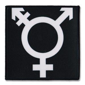 May include: A square black patch featuring a white transgender symbol. The symbol combines the male and female symbols with an arrow. The patch has a black border and is likely made of fabric.