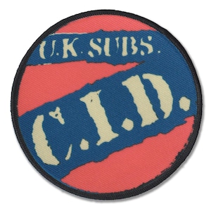 Könnte beinhalten: Ein runder, rot-blauer Patch mit dem Text "U.K. Subs." und "C.I.D." in Weiß.