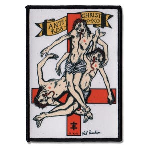 May include: A rectangular embroidered patch with a black border featuring a red cross and three figures in a tangled pose. A yellow banner at the top reads ANTI-CHRIST with symbols. The figures have red number sixes on their chests and tongues.