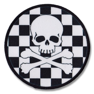 May include: A white skull and crossbones design on a black and white chequered background. The patch is round and has a black border.