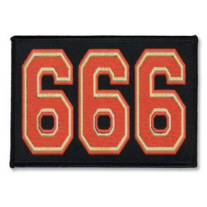 Op de afbeelding: Zwarte patch met het nummer 666 in grote, oranje, omrande letters.