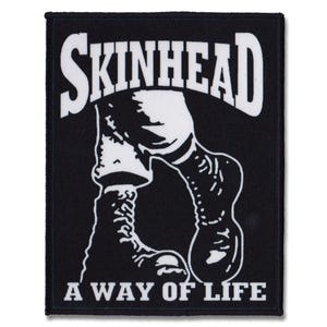 Könnte beinhalten: Schwarz-weiß-Patch mit dem Text "SKINHEAD" in großer weißer Schrift. Unter dem Text befindet sich eine weiße Silhouette eines Beins, das einen Stiefel trägt. Der Text "A WAY OF LIFE" befindet sich unter dem Bild.