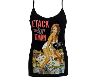 May include: Black spaghetti strap tank top with a retro movie poster graphic. The graphic features a giant woman destroying a city, with the text "ATTACK of the 50 FT. WOMAN" in red and white.