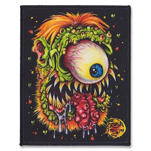 Può includere: Una toppa nera con un'illustrazione colorata di un mostro con un solo occhio, una grande bocca aperta e saliva che cola. Il mostro ha la pelle verde, un occhio giallo e capelli arancioni.
