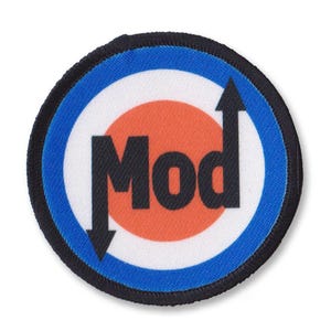 Peut inclure: Un patch rond noir et blanc avec un anneau bleu autour de l'extérieur. Le centre du patch a un cercle rouge avec le mot "Mod" en lettres noires. Il y a des flèches noires pointant vers le haut et vers le bas de chaque côté du mot "Mod".