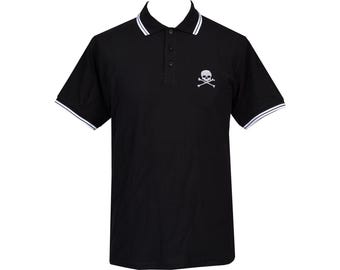 May include: Black polo shirt with a white skull and crossbones design on the chest. The shirt has a white tipped collar and white trim on the sleeves.