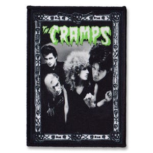 Può includere: Toppa per band in bianco e nero con un logo verde "The Cramps" e una foto della band. La toppa ha un bordo nero con un design di teschio e ossa incrociate.