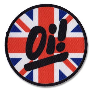Könnte beinhalten: Ein runder Patch mit einer schwarzen und weißen "Oi!" Grafik auf einem roten, weißen und blauen Union Jack Flaggenhintergrund.