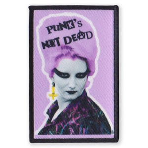 May include: An embroidered patch featuring a woman's face and the text "Punk's Not Dead" in purple and black.