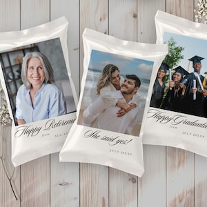 May include: Three white bags with photos and text. The first bag has a photo of a woman and the text "Happy Retirement from ALL AT". The second bag has a photo of a couple and the text "She said yes! JULY 20XXP". The third bag has a photo of a group of people in graduation gowns and the text "Happy Graduation from JULY 20XXP".