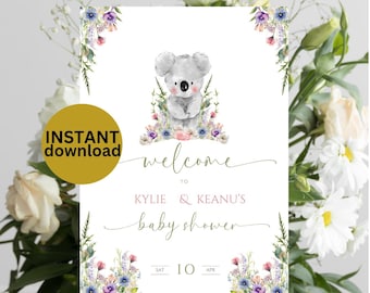 Op de afbeelding: Een afdrukbaar welkomsbord voor een babyshower met een schattige koala-illustratie omringd door aquarelbloemen. Het bord zegt "Welkom bij Kylie & Keanu's Baby Shower" en de datum is zaterdag 10 april.