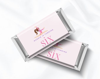 May include: Two pink and white chocolate bar wrappers with a silver foil border. The wrappers feature a cartoon illustration of a girl doing a handstand on a balance beam. The text on the wrappers reads "Maddie is turning Six" and "die is turning Six".
