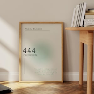May include: A framed poster with a light green and blue gradient background. The poster features the text "Angel Number 444 Protection" and the message "Your angels are watching over you and working to protect you from harm. Trust in your own inner strength and intuition. You are not alone."