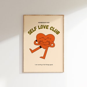 May include: A beige poster with a brown frame features a cartoon heart hugging itself. The text "SELF LOVE CLUB" is in green letters above the heart. The text "MEMBERSHIP PASS" is in smaller green letters above the text "SELF LOVE CLUB". The text "I am worthy of all things good" is in black letters below the heart.