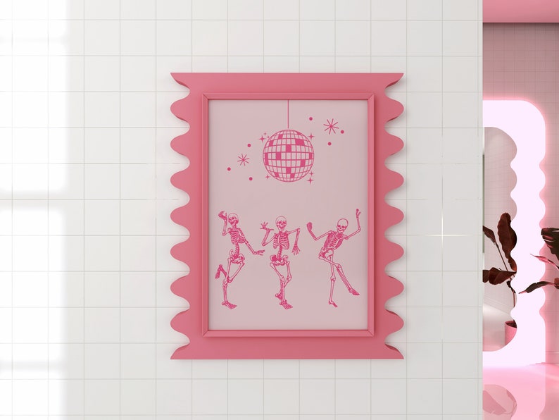 Puede incluir: Una impresi&oacute;n enmarcada en rosa con un fondo rosa que presenta tres esqueletos bailando bajo una bola de discoteca. El marco tiene un borde festoneado.