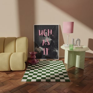 Puede incluir: Una impresi&oacute;n enmarcada con un retrato en blanco y negro de una mujer con el texto "UGH, AS IF" en letras rosas. La impresi&oacute;n est&aacute; colgada en una pared con una alfombra a cuadros verdes y blancos delante.