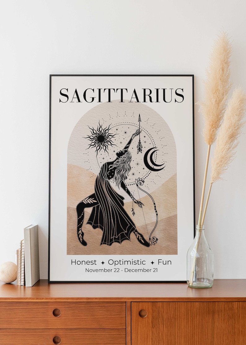 May include: Black framed Sagittarius zodiac art print. The illustration features a woman with a bow and arrow, a sun, and a crescent moon. Text includes "Sagittarius", "Honest + Optimistic + Fun", and the dates November 22 - December 21.