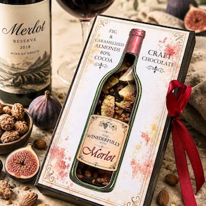 Può includere: Una scatola rettangolare di cioccolato artigianale con un'apertura a forma di bottiglia che rivela cioccolato fondente con fichi e mandorle caramellate. La confezione riporta il testo Fig & Caramelized Almonds 60% Cocoa, Craft Chocolate e Pairs Winederfully With Merlot, decorato con un nastro rosso.