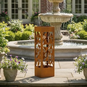 Könnte beinhalten: Eine hohe, rechteckige Gartenlaterne aus rostbraunem Metall mit geometrischen Aussparungen. Die Laterne steht auf einer Steinterrasse vor einem mehrstufigen Brunnen und einem Backsteinhaus. Das Bild zeigt Topfpflanzen mit lila Blüten.