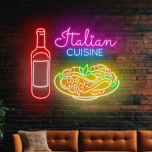 May include: Neon sign with the text "Italian Cuisine" in pink and purple, a plate of pasta with shrimp in yellow and green, and a red wine bottle. The sign is on a brick wall behind a brown leather couch.