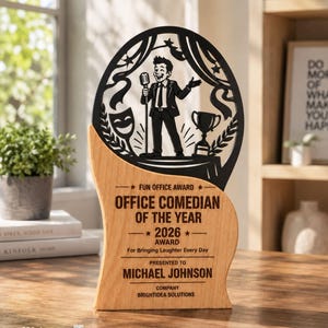May include: A wooden award plaque featuring a black laser-cut topper with a comedian holding a microphone, a trophy, and a theater mask. The wood base is engraved with "FUN OFFICE AWARD," "OFFICE COMEDIAN OF THE YEAR 2026," and "MICHAEL JOHNSON."