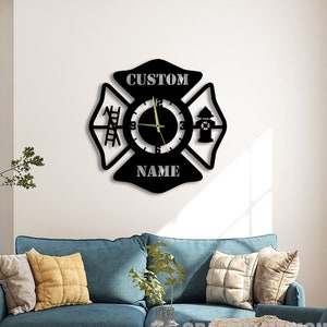 Puede incluir: Reloj de pared negro y blanco con un diseño de cruz de Malta de bombero. La esfera del reloj presenta una escalera, una boca de incendios y las palabras "CUSTOM NAME".