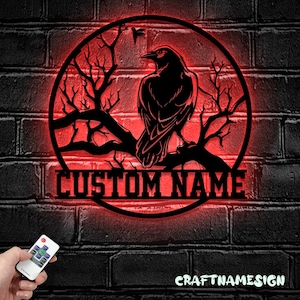 May include: A red illuminated metal sign with a black silhouette of a raven perched on a branch. The sign is circular and has the text "CUSTOM NAME" below the raven.