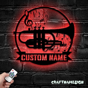 May include: A red illuminated wall sign with a black silhouette of a trumpet and musical notes. The sign has a banner at the bottom that says "CUSTOM NAME".