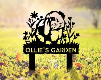 May include: Black metal garden stake with a silhouette of a rabbit and flowers. The stake has a sign that reads "Ollie's Garden".