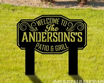 Puede incluir: Señal de bienvenida negra y dorada con el texto "Bienvenido a The Andersons's Patio & Grill".