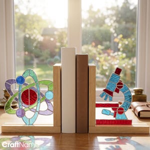 Puede incluir: Dos sujetalibros de madera con inserciones de vidrieras. El sujetalibros izquierdo muestra un diseño de átomo multicolor con vidrio rojo, azul, verde y morado. El derecho presenta un diseño de microscopio de vidriera en azul y rojo.