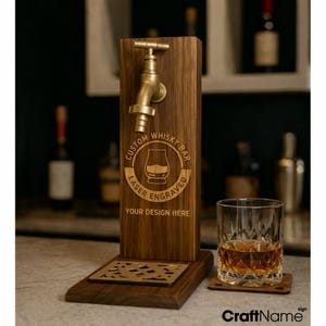 May include: A wooden whisky dispenser with a brass tap and the text "CUSTOM WHISKY BAR LASER ENGRAVED YOUR DESIGN HERE". A glass of whisky sits next to the dispenser on a wooden coaster.