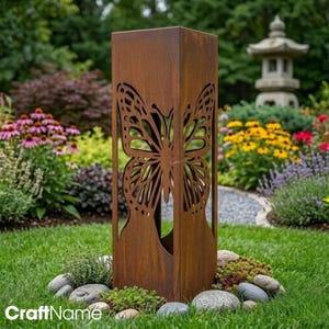 Può includere: Una scultura da giardino alta e rettangolare realizzata in metallo arrugginito e usurato. La struttura presenta un grande e complesso design a farfalla ritagliato sulla parte anteriore, che mostra dettagliati motivi alari. Il metallo ha una finitura marrone ossidata.