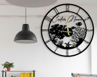 May include: Black metal wall clock with a custom name and a silhouette of a coral reef with fish. The clock has Roman numeral hour markers and a black background.
