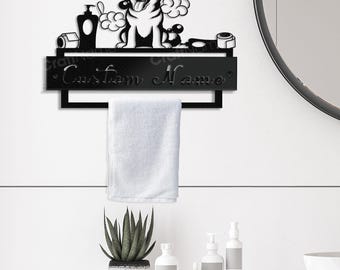 Puede incluir: Un toallero de pared de metal negro con un recorte de un perro husky rodeado de burbujas de jabón, una botella y rollos de papel higiénico. El letrero rectangular incluye el texto Custom Name y una barra para colgar una toalla.